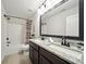Well-lit bathroom featuring double sinks, a granite countertop, and a shower with a tub at 6825 Concord Brook Ln, Cumming, GA 30028