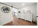 Bedroom featuring a sliding barn door, dresser, and hardwood floors at 6825 Concord Brook Ln, Cumming, GA 30028