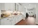 Butlers pantry showcasing white cabinets, countertops, and stylish decor leading into the living room at 6825 Concord Brook Ln, Cumming, GA 30028