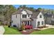 A charming two-story home with a manicured lawn and colorful landscaping, creating a welcoming curb appeal at 6825 Concord Brook Ln, Cumming, GA 30028