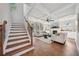 Bright living room boasts a fireplace, coffered ceilings, and hardwood floors, with stairs leading up at 6825 Concord Brook Ln, Cumming, GA 30028