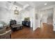 Living room showcasing the coffered ceiling, hardwood floors, stylish furniture, and staircase access at 6825 Concord Brook Ln, Cumming, GA 30028