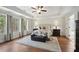 A spacious main bedroom with hardwood floors, tray ceiling, and nature views at 6825 Concord Brook Ln, Cumming, GA 30028
