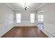 Classic dining room with wainscoting, hardwood floors, and modern chandelier fixture at 1561 Cooks Pond Dr, Powder Springs, GA 30127