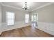 Formal dining room with classic wainscoting, hardwood floors, and elegant chandelier at 1561 Cooks Pond Dr, Powder Springs, GA 30127