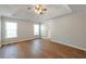 Main bedroom with tray ceiling, hardwood floors, and two windows providing natural light at 1561 Cooks Pond Dr, Powder Springs, GA 30127