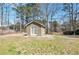A backyard outbuilding with a covered entry, white doors, and neutral siding blends into the landscape at 1561 Cooks Pond Dr, Powder Springs, GA 30127