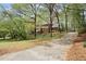 Traditional brick home nestled amidst mature trees, featuring a long driveway at 2115 Hawthorne Pt, Marietta, GA 30062