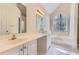 Bathroom with dual sinks, large soaking tub, and arched window at 534 Creekstone Dr, Jonesboro, GA 30236