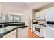 Well-lit kitchen with white appliances, wood floors, and adjacent breakfast area at 534 Creekstone Dr, Jonesboro, GA 30236