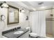 Cozy bathroom with granite countertop, decorative mirror, and shower with white curtain at 570 Glen Eagles Se Cir, Marietta, GA 30067