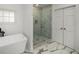 Bathroom featuring a soaking tub, glass shower, and marble floors at 570 Glen Eagles Se Cir, Marietta, GA 30067