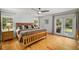 Sunlit main bedroom featuring a wooden bed frame, hardwood floors, and access to a private deck at 570 Glen Eagles Se Cir, Marietta, GA 30067