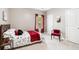 Well-lit bedroom showcasing a comfortable bed with red accents, chair, and a serene ambiance at 12551 Alcovy Rd, Covington, GA 30014