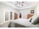 Relaxing bedroom with decorative glass doors, tray ceilings, and neutral carpet at 12551 Alcovy Rd, Covington, GA 30014