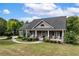 Charming home with a covered front porch, stone accents, and a well-manicured lawn at 12551 Alcovy Rd, Covington, GA 30014