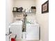 Bright laundry room equipped with a washer and dryer and storage shelving at 12551 Alcovy Rd, Covington, GA 30014