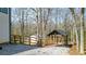 Fenced backyard featuring a storage shed and covered area, surrounded by tall trees at 416 Delane Dr, Dallas, GA 30157