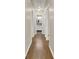 Hallway with hardwood floors leads to a bathroom with white vanity and a mirror at 416 Delane Dr, Dallas, GA 30157