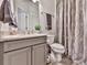 Well-lit bathroom featuring a gray vanity, granite countertop, and patterned shower curtain at 134 Edinburgh Dr, Canton, GA 30115