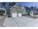 Charming two-story home featuring a stone and brick facade, a two-car garage, and well-maintained landscaping at 134 Edinburgh Dr, Canton, GA 30115