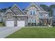 Charming two-story home featuring a stone and brick facade, two-car garage, and well-manicured lawn at 134 Edinburgh Dr, Canton, GA 30115