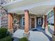 Charming covered front porch features stone accents and a wood front door at 134 Edinburgh Dr, Canton, GA 30115
