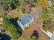 Aerial view of blue home with large backyard, mature trees, deck and lush landscaping at 210 Timber Laurel Ct, Lawrenceville, GA 30043