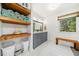 Bright bathroom featuring a double vanity, wood shelves, storage for towels, and a window at 210 Timber Laurel Ct, Lawrenceville, GA 30043