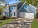Two-story home with blue siding, an attached garage, and a concrete driveway with a manicured lawn at 210 Timber Laurel Ct, Lawrenceville, GA 30043