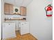 Functional laundry room with overhead cabinets, shelving and a fire extinguisher for added safety at 210 Timber Laurel Ct, Lawrenceville, GA 30043