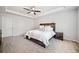 This bedroom features a tray ceiling, ceiling fan, and a rustic wood headboard with sconces at 3505 Aqua Point Pl, Cumming, GA 30041