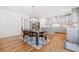 Open-concept dining room and kitchen featuring hardwood floors and stainless steel appliances at 3505 Aqua Point Pl, Cumming, GA 30041