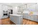 The modern kitchen features an island, stainless steel appliances, and gray cabinetry at 3505 Aqua Point Pl, Cumming, GA 30041