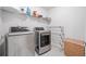 This laundry room offers modern stainless steel washer and dryer, shelving and tile flooring at 3505 Aqua Point Pl, Cumming, GA 30041