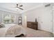 Main bedroom featuring a ceiling fan, large dresser and mirror, and two large windows at 3505 Aqua Point Pl, Cumming, GA 30041
