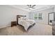 A main bedroom with a ceiling fan, carpeted floor, and a wooden headboard and side table at 3505 Aqua Point Pl, Cumming, GA 30041