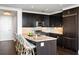 Modern kitchen featuring stainless steel appliances, dark wood cabinetry, and breakfast bar at 3630 Peachtree Ne Rd # 2009, Atlanta, GA 30326