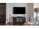 Stylish entertainment area with mounted TV, metal cabinet, guitars, and cozy leather seating at 3630 Peachtree Ne Rd # 2009, Atlanta, GA 30326