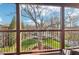 Charming balcony with wood railings overlooking a lush green lawn and mature trees at 5910 Bond St # 401, Cumming, GA 30040