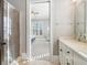 Bathroom with a sleek glass shower, adjacent to the vanity with an open doorway to the primary bedroom at 5910 Bond St # 401, Cumming, GA 30040