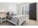 Serene bedroom featuring a white bed, soft grey accents, and natural light streaming through the shuttered windows at 5910 Bond St # 401, Cumming, GA 30040