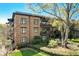 Brick condominium building featuring private balconies, detailed trim work, and manicured landscaping at 5910 Bond St # 401, Cumming, GA 30040