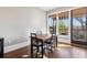 Bright dining area with hardwood floors, a wooden table, and a view through the window and glass door at 5910 Bond St # 401, Cumming, GA 30040