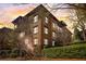 Multi-story brick condo with multiple levels of balconies offering neighborhood views at sunset at 5910 Bond St # 401, Cumming, GA 30040