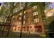 Brick condos feature multiple balconies and ground-level garages, with a backdrop of sunset skies at 5910 Bond St # 401, Cumming, GA 30040