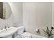 Half bathroom featuring a pedestal sink, toilet, round mirror, and a decorative plant at 5910 Bond St # 401, Cumming, GA 30040