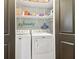 Convenient laundry closet features a washer and dryer with shelving for storage and organization at 5910 Bond St # 401, Cumming, GA 30040