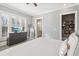 Bright bedroom with plantation shutters, a TV, and grey furnishings at 5910 Bond St # 401, Cumming, GA 30040
