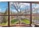 Covered porch view overlooking beautiful landscaped gardens and mature trees under a bright blue sky at 5910 Bond St # 401, Cumming, GA 30040